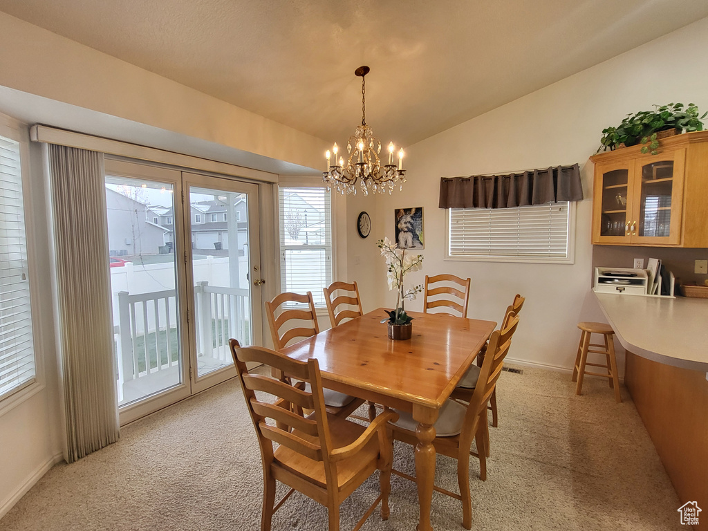 Dining room with light colored carpet and a healthy amount of sunlight