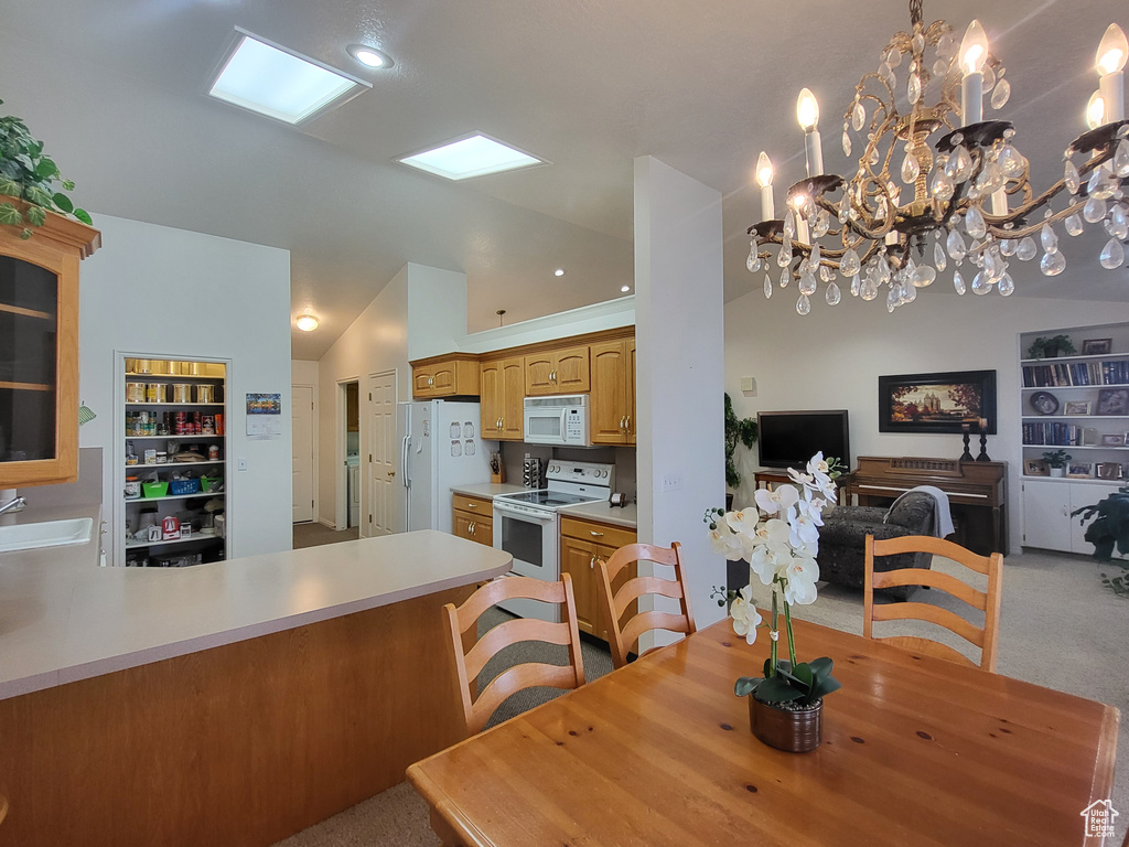 Dining area featuring built in shelves, lofted ceiling, a notable chandelier, and light carpet