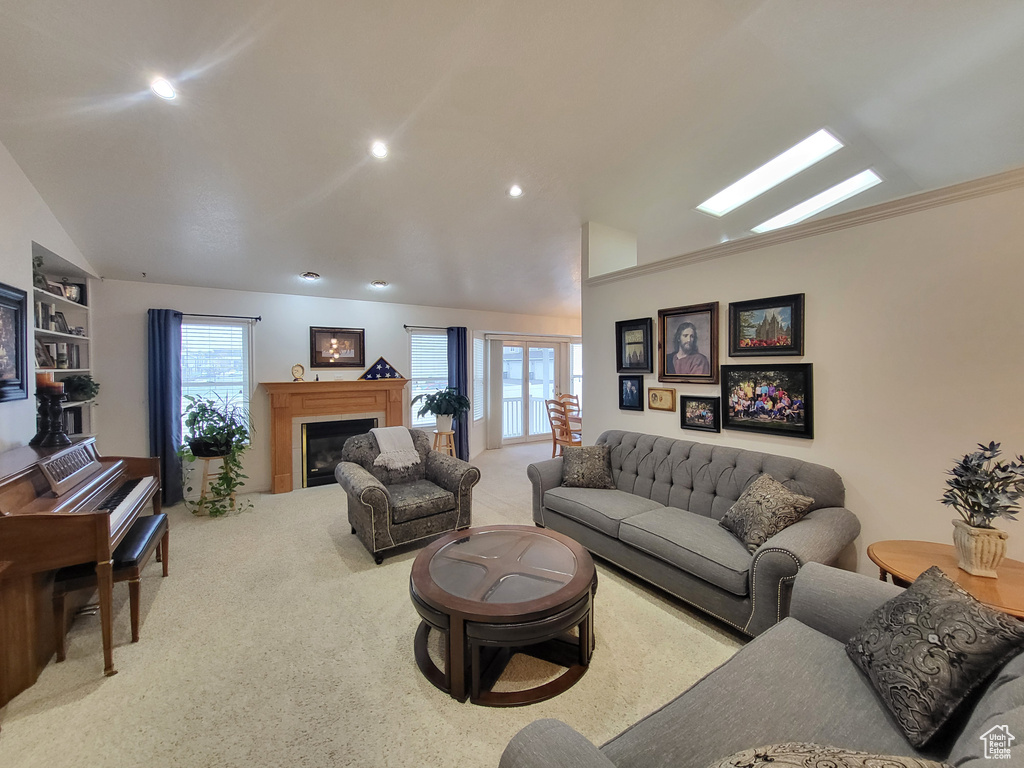 Living area with carpet floors, recessed lighting, vaulted ceiling, and a glass covered fireplace