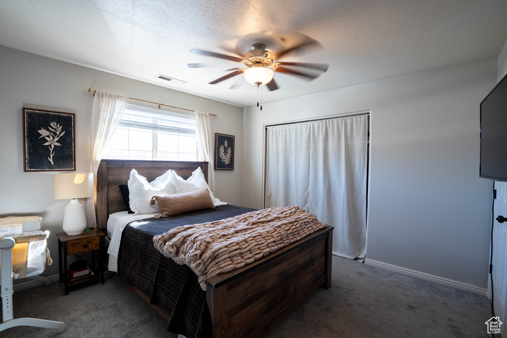 Carpeted bedroom with visible vents, baseboards, and ceiling fan
