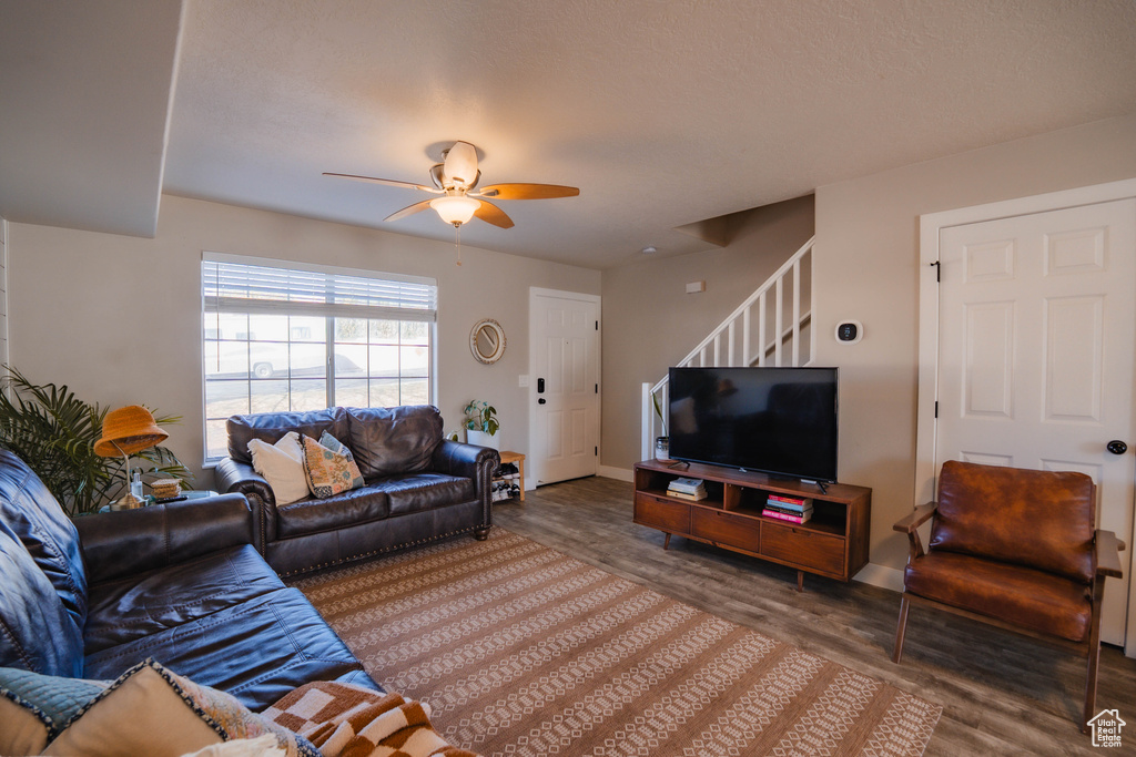 Living room featuring stairway, baseboards, ceiling fan, and wood finished floors