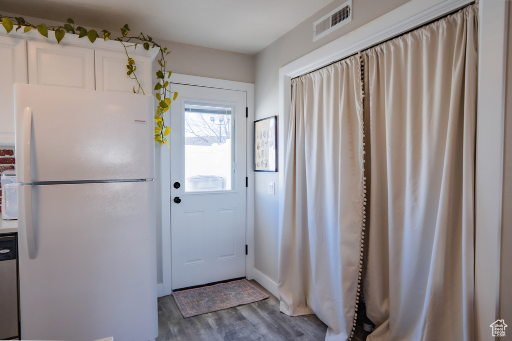 Entryway with wood finished floors and visible vents
