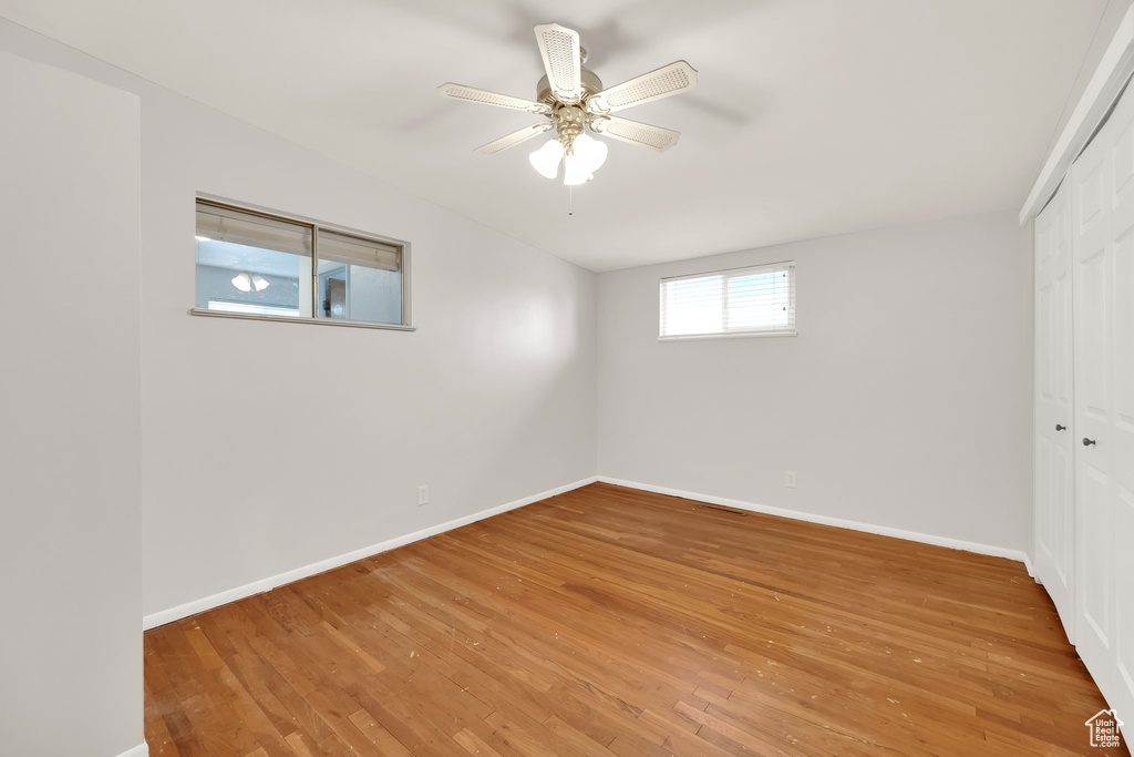 Unfurnished bedroom with light wood-style floors, baseboards, a ceiling fan, and a closet