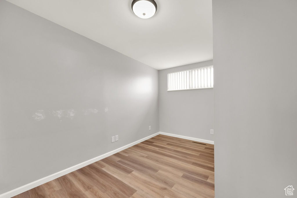 Empty room with baseboards, light wood-type flooring, and visible vents