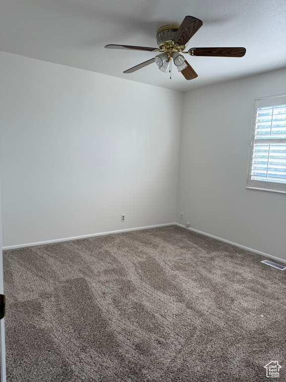 Spare room featuring baseboards, a ceiling fan, carpet flooring, and visible vents
