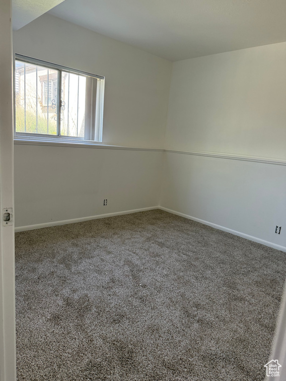 Carpeted empty room featuring baseboards