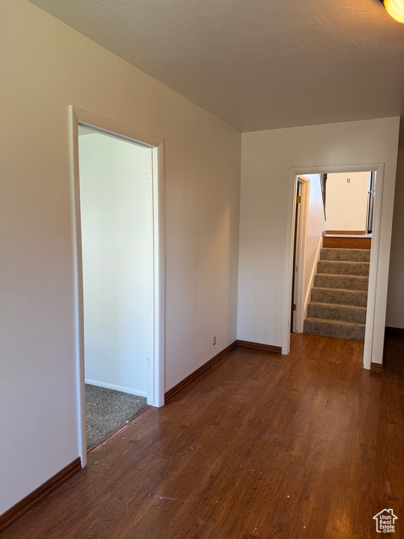 Empty room with baseboards, stairs, and wood finished floors