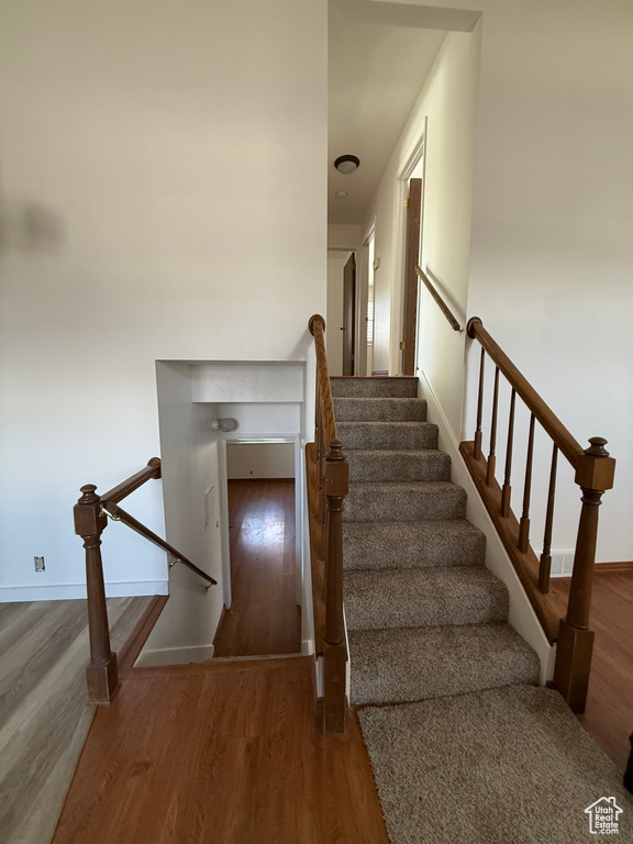 Staircase featuring baseboards and wood finished floors