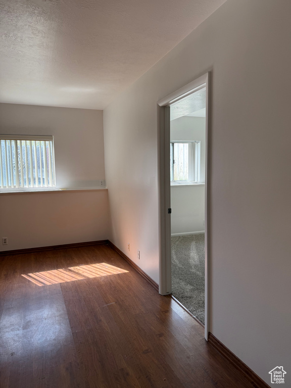 Spare room featuring baseboards, wood finished floors, and a wealth of natural light
