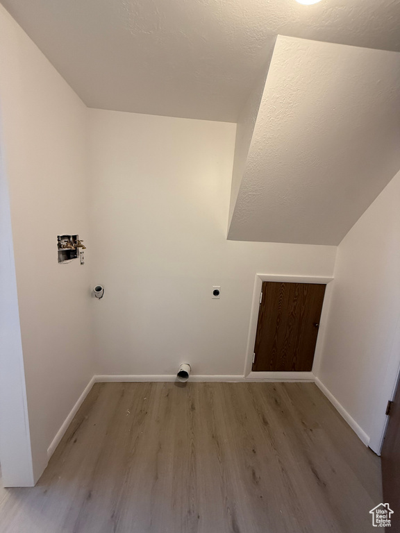 Clothes washing area with light wood-style floors, washer hookup, baseboards, and electric dryer hookup