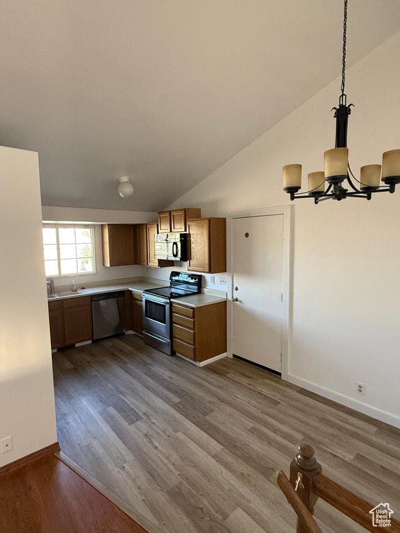 Kitchen featuring an inviting chandelier, light countertops, a sink, dark wood finished floors, and stainless steel appliances