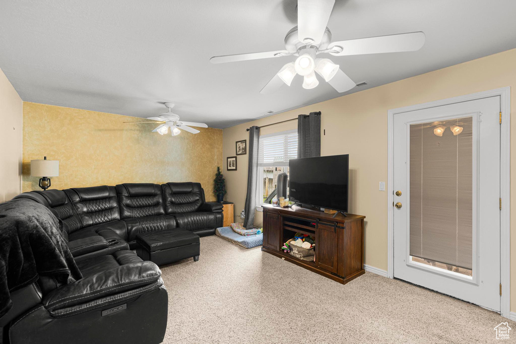 Living room with carpet flooring and ceiling fan