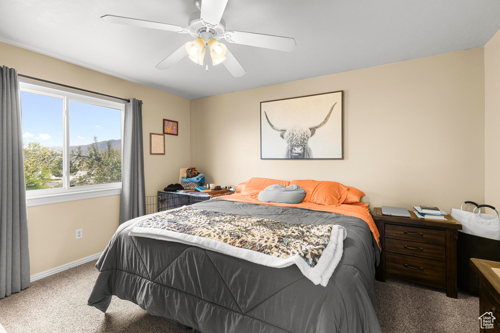 Carpeted bedroom with baseboards and a ceiling fan