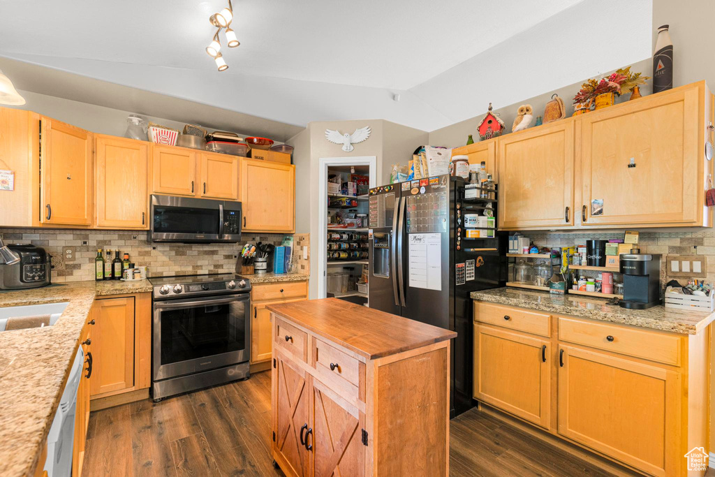 Kitchen featuring appliances with stainless steel finishes, light brown cabinets, butcher block countertops, lofted ceiling, and backsplash
