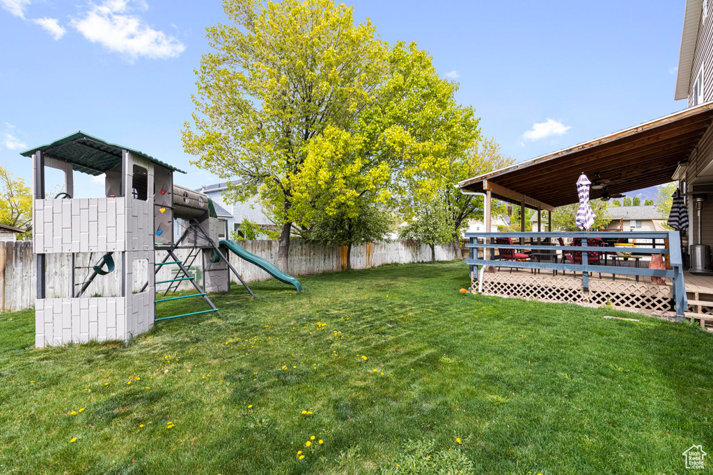 View of yard with a fenced backyard, a playground, and a deck
