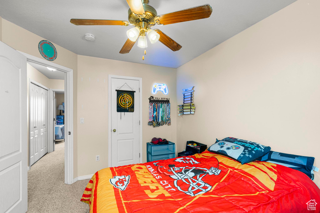 Carpeted bedroom with baseboards and ceiling fan
