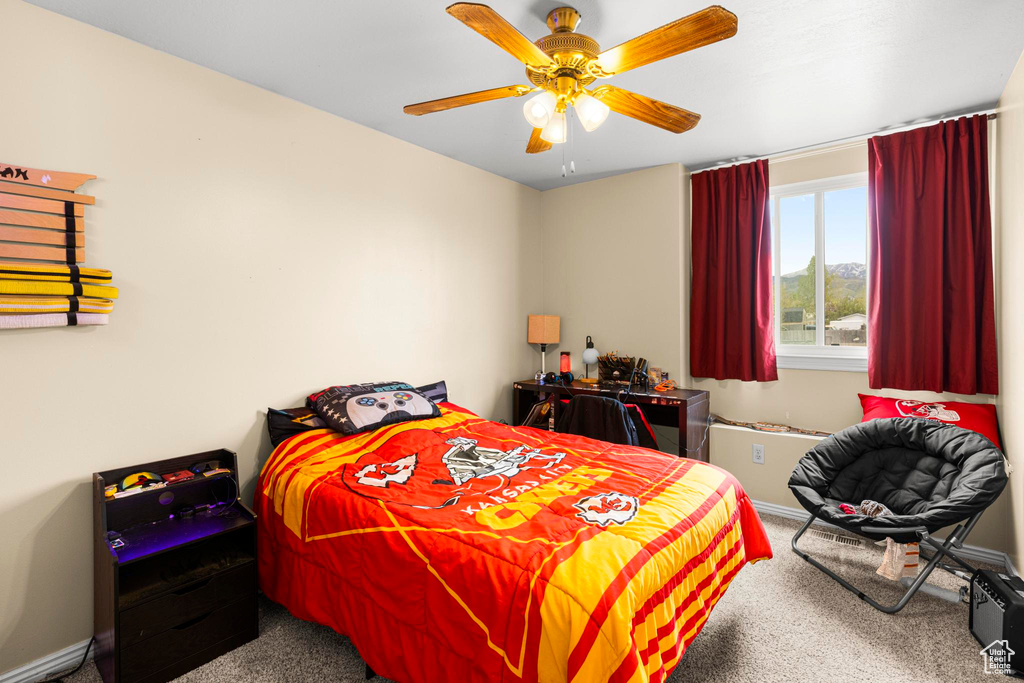 Carpeted bedroom with baseboards and ceiling fan