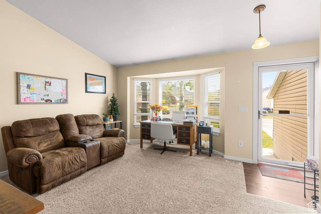 Carpeted living room with baseboards, wood finished floors, and lofted ceiling