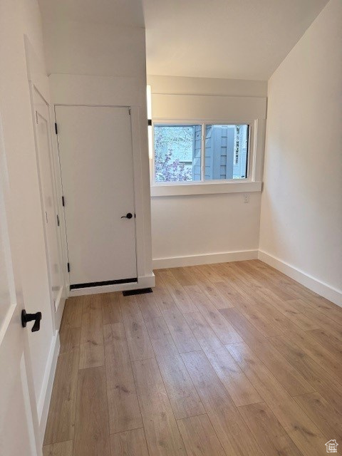 Spare room with baseboards, visible vents, and light wood-type flooring