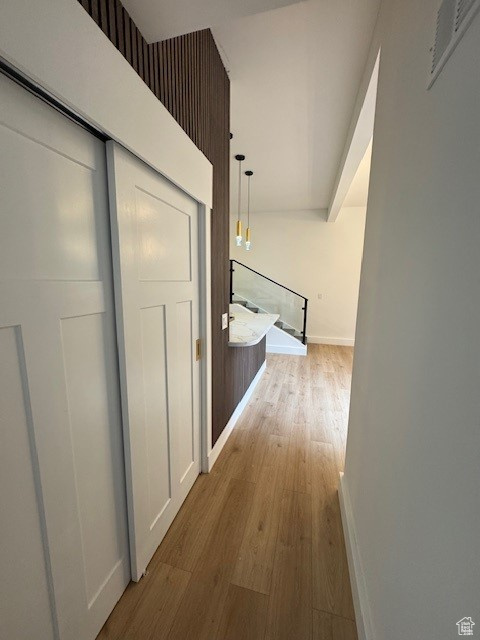 Corridor featuring baseboards, visible vents, and wood finished floors