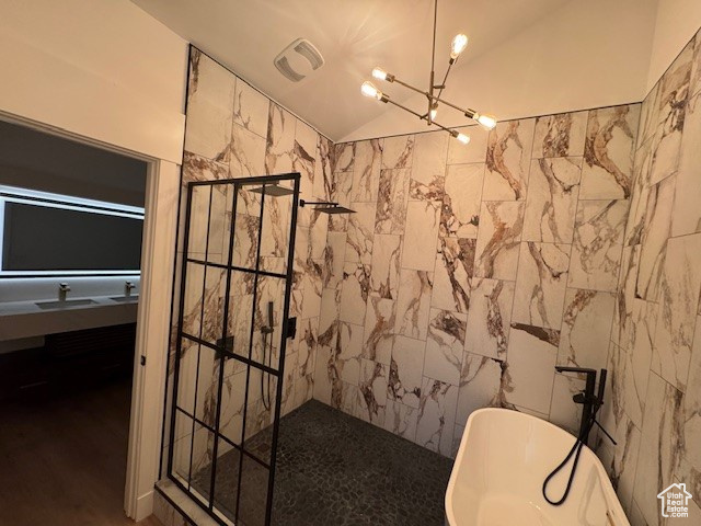Full bathroom featuring a walk in shower, a notable chandelier, lofted ceiling, visible vents, and a soaking tub
