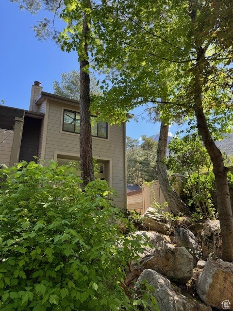 View of side of property with fence and a chimney