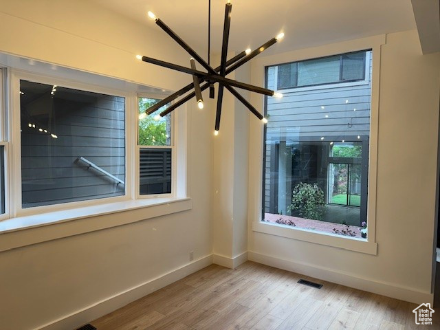 Spare room with baseboards, visible vents, a healthy amount of sunlight, and light wood finished floors