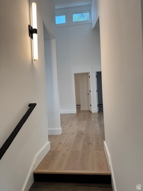 Hall featuring baseboards, an upstairs landing, and light wood-style flooring