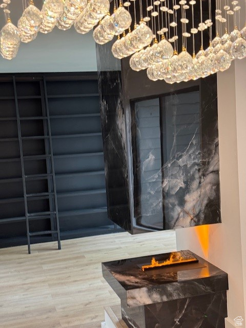 Details with an inviting chandelier, wood finished floors, and an outdoor fire pit
