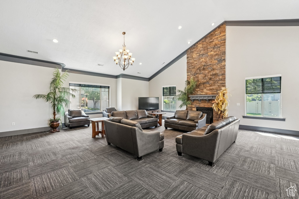 Living room with high vaulted ceiling, carpet, a chandelier, a fireplace, and recessed lighting
