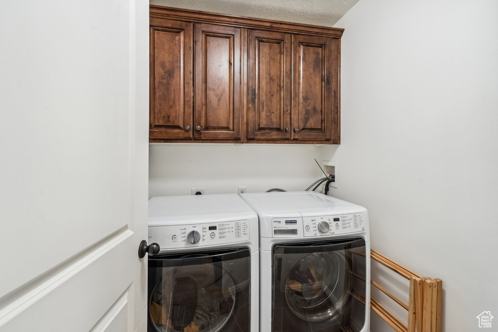 Laundry area featuring washing machine and dryer and cabinet space