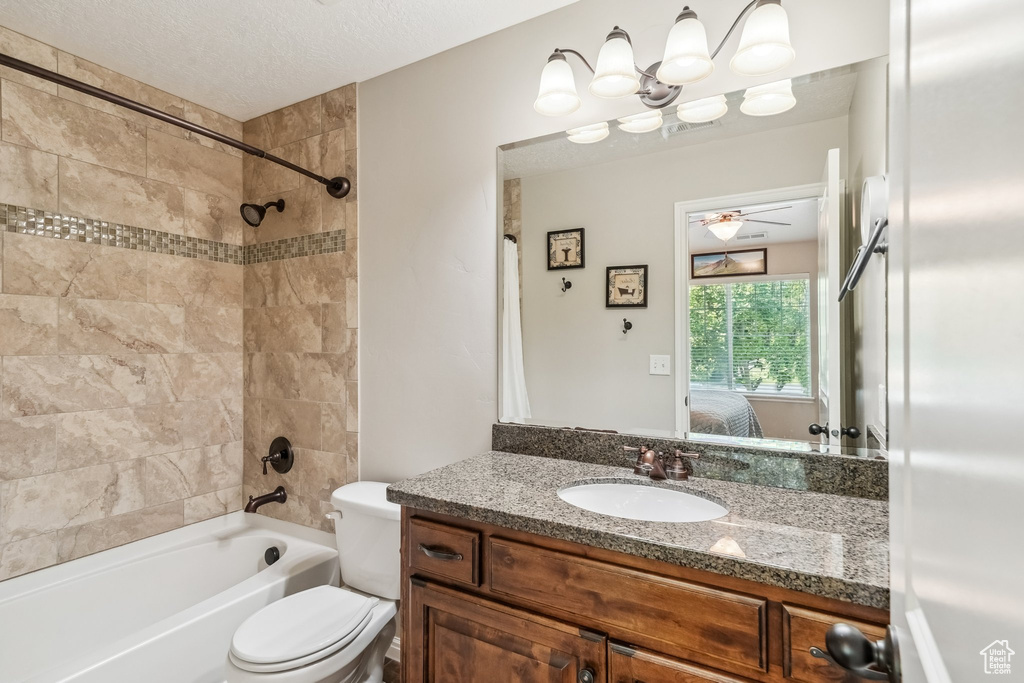Bathroom featuring connected bathroom, vanity, washtub / shower combination, toilet, and a ceiling fan