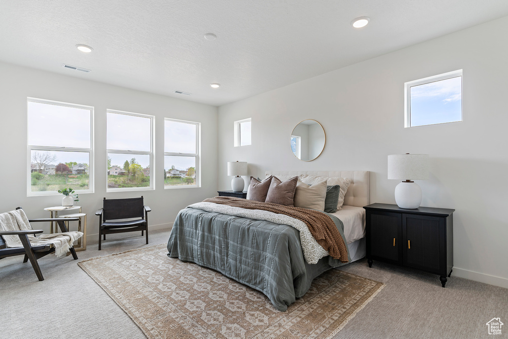 Bedroom featuring light colored carpet, visible vents, and recessed lighting
