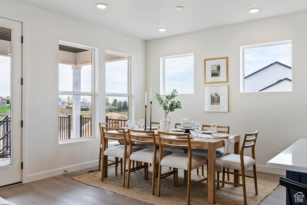 Dining space with recessed lighting, a wealth of natural light, and light wood-style floors