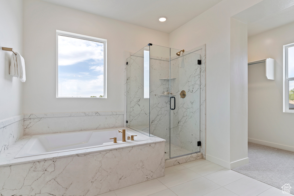 Bathroom featuring tile patterned flooring, a marble finish shower, and a bath