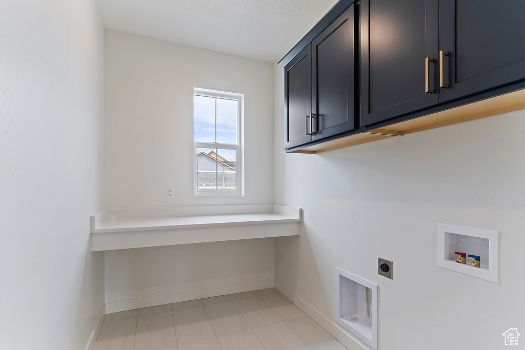 Washroom featuring washer hookup, baseboards, electric dryer hookup, and cabinet space