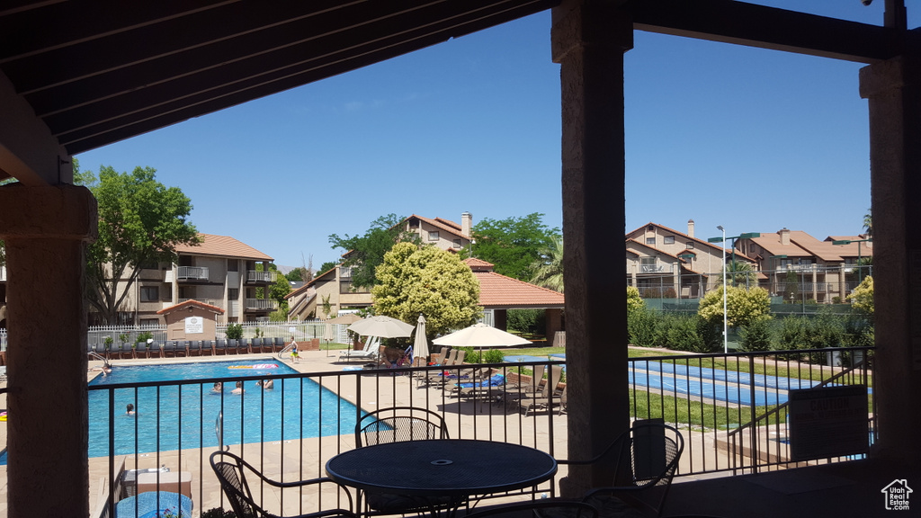 Pool with a patio, fence, and a residential view