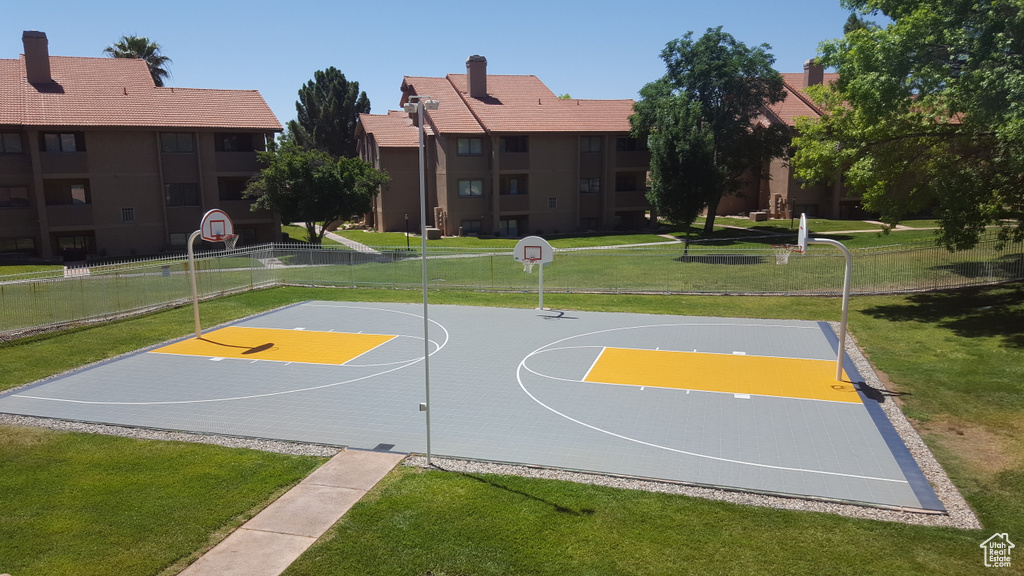 View of basketball court featuring community basketball court, a yard, and fence