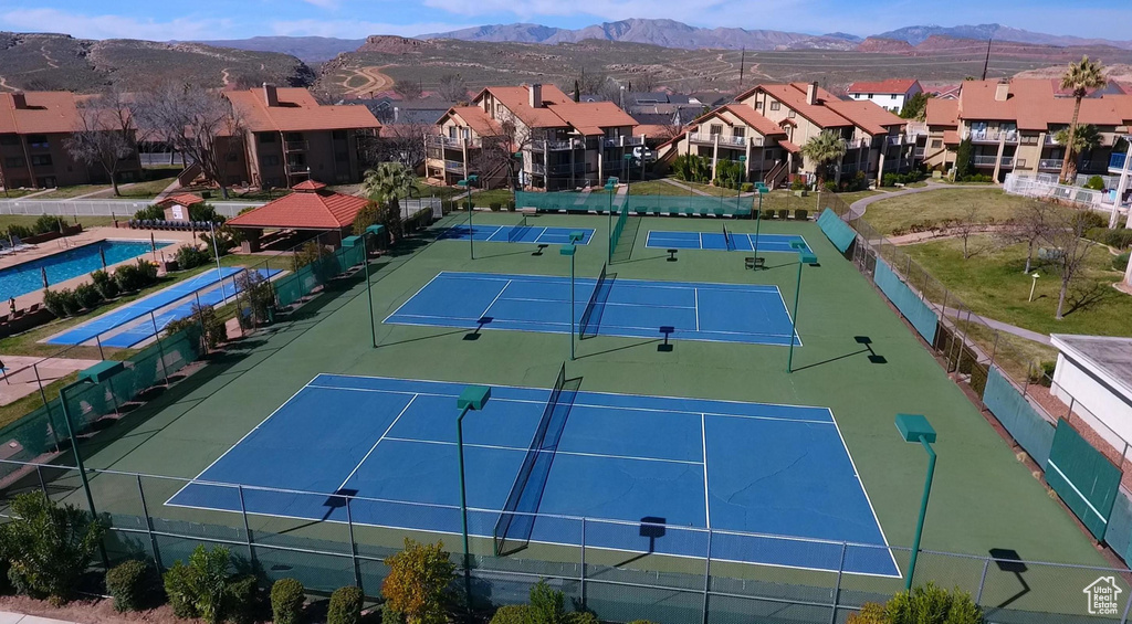 View of sport court featuring fence, a mountain view, and a residential view