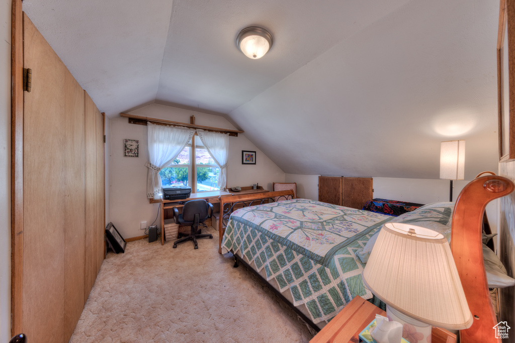 Bedroom with vaulted ceiling and carpet flooring