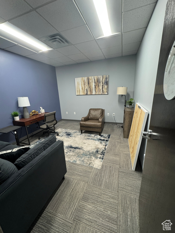 Carpeted living room with visible vents and a paneled ceiling