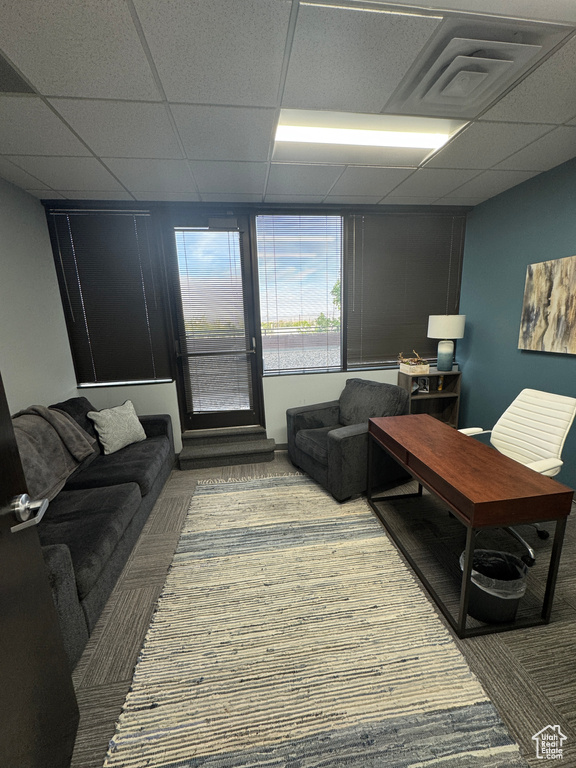 Living area featuring carpet floors, a paneled ceiling, and visible vents