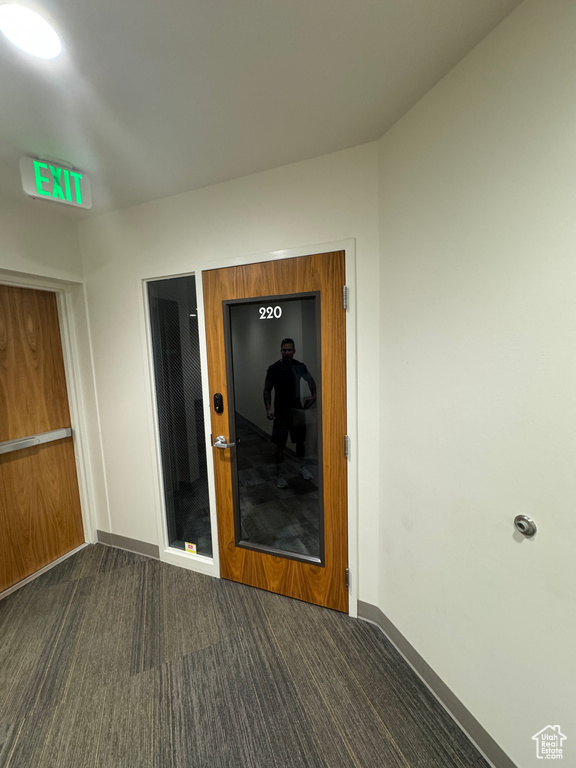 Interior space with dark colored carpet and baseboards
