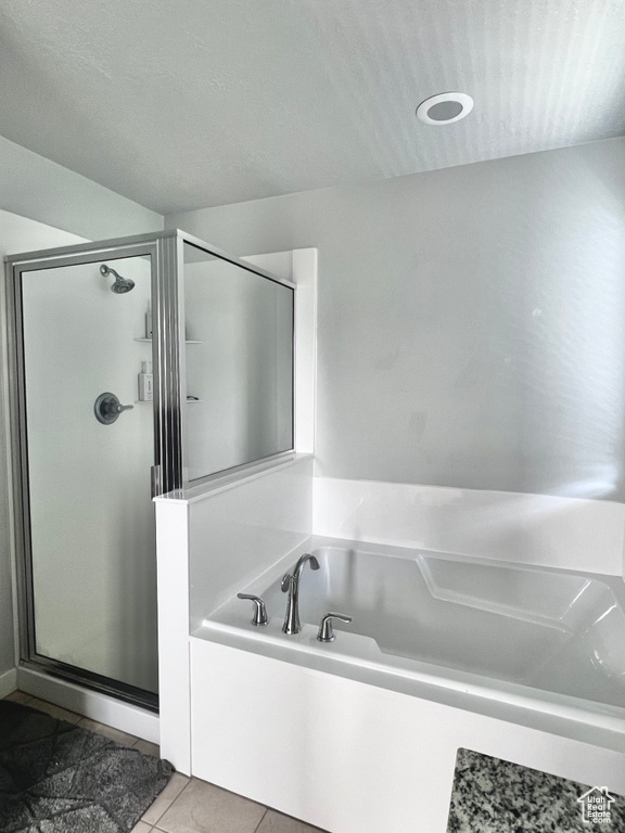 Full bath featuring tile patterned floors, a shower stall, and a bath