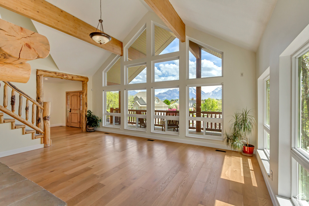 Interior space with wood finished floors, a wealth of natural light, and high vaulted ceiling
