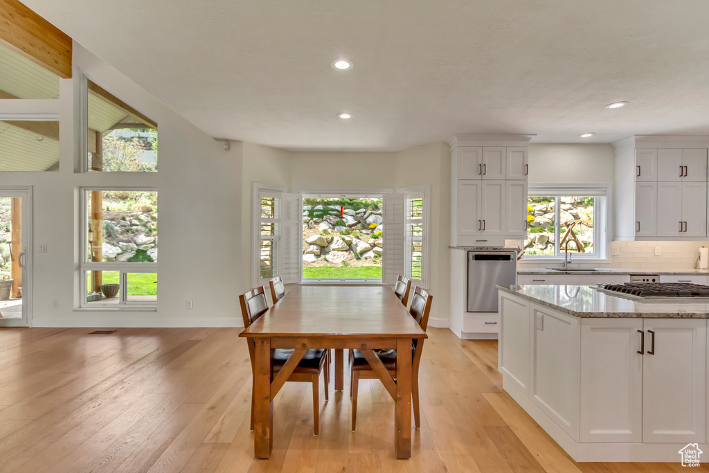 Dining area with baseboards, recessed lighting, and light wood-style flooring