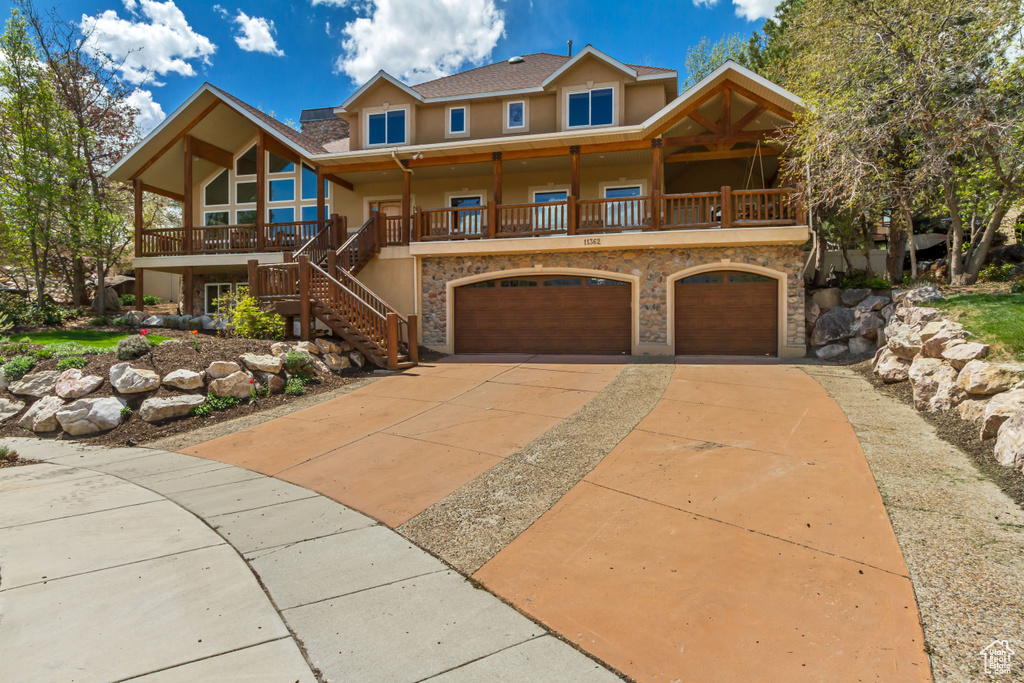View of front of home featuring a garage, stucco siding, concrete driveway, a porch, and stairway