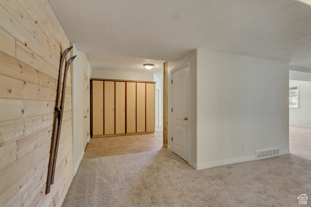 Hall with carpet floors, baseboards, and visible vents