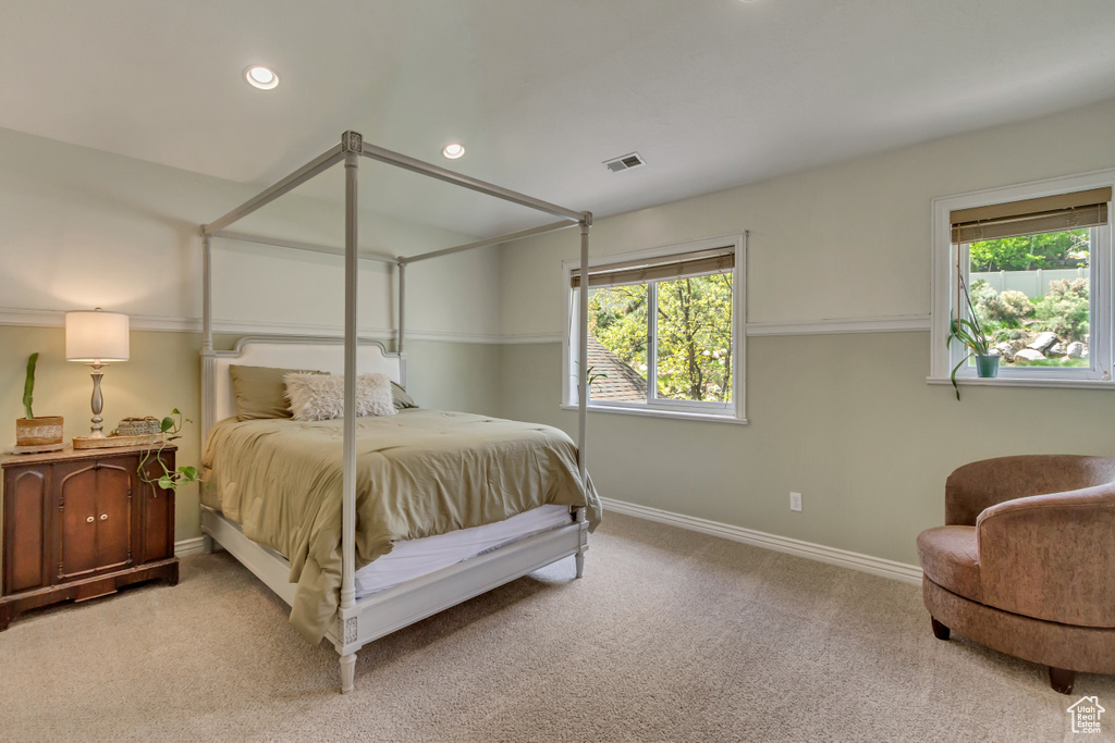 Bedroom with light colored carpet, baseboards, visible vents, and recessed lighting