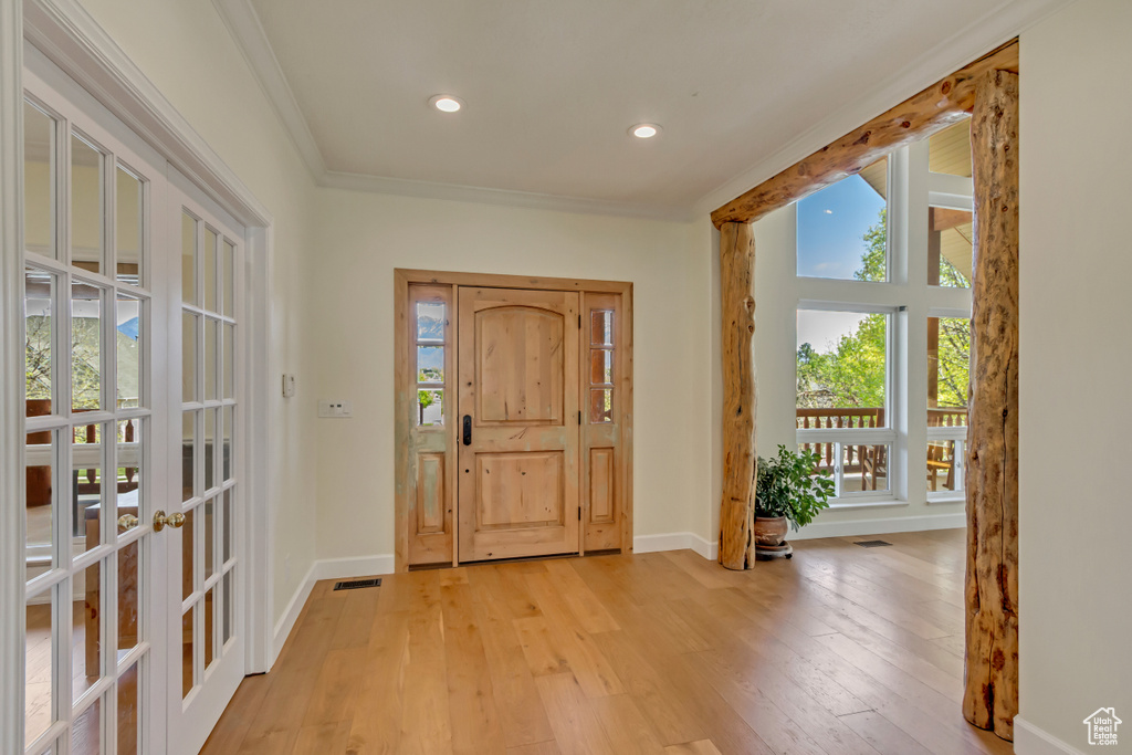 Foyer entrance with a healthy amount of sunlight, french doors, and light wood finished floors